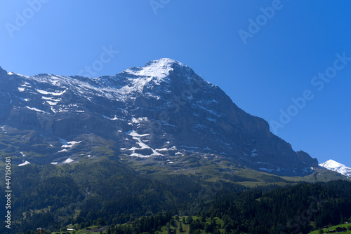 Fototapeta Naklejka Na Ścianę i Meble -  Mountain peak Eiger at Bernese highland on a sunny summer day with blue sky background and clouds in the foreground. Photo taken July 20th, 2021, Lauterbrunnen, Switzerland.