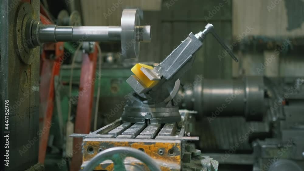 Side view. A worker in production processes a polyurethane part on a