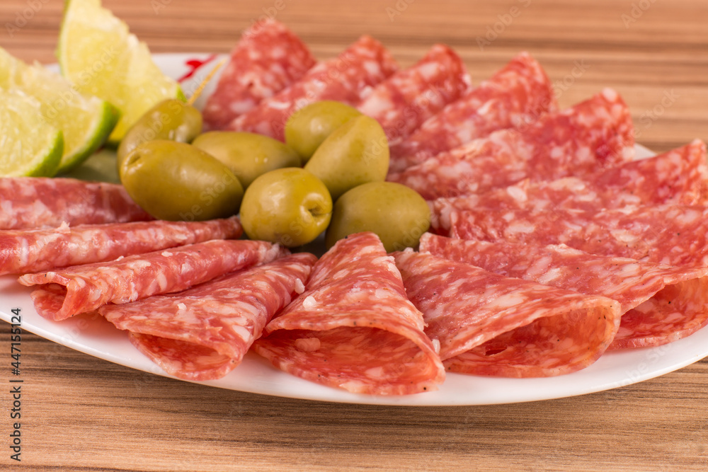 portion of salami on wooden background portion of salami on wooden background