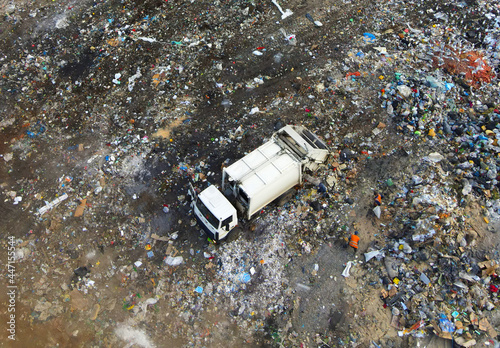 Arial view of garbage truck during unloading the rubbish and food waste. Recycling garbage. Work at landfill. Waste conservation. Trash disposal on rubbish dump. Soft focus