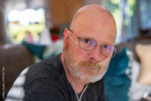 Old man with oxygen tank hose in nose battling medical condition in lungs - Covid-19 pneumonia