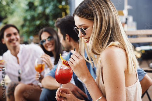 Group of young people drinking cocktails at a summer bar during the day