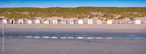 beach huts on dutch wadden island of texel at dusk under blue sky in summer photo