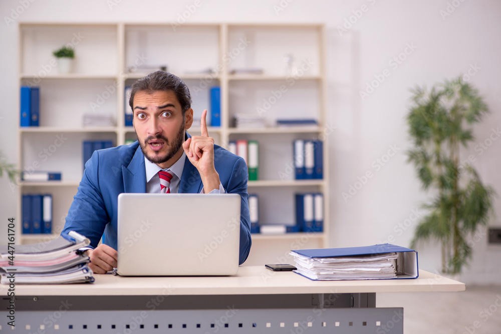 Young male employee working in the office Young male employee working in the office