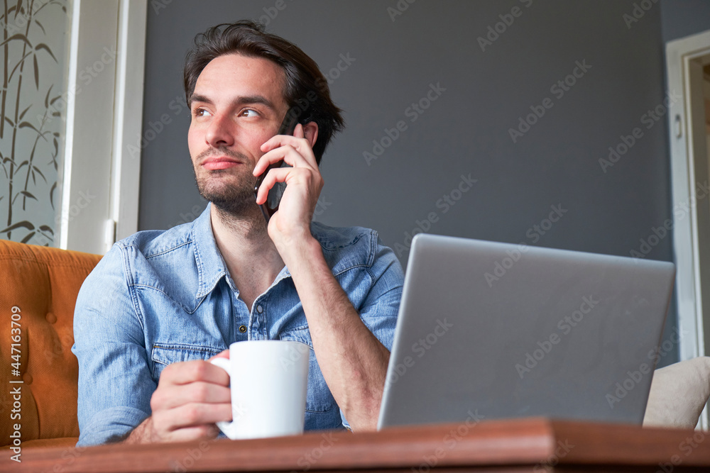 Single male sitting at home, drinking his coffee and doing his online jobs Single male sitting at home, drinking his coffee and doing his online jobs