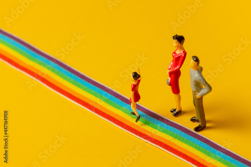 little parents and daughter figures on the LGBT rainbow path