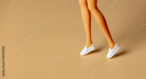 White female doll legs in white shoes