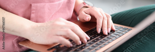 Female hands typing on laptop keyboard closeup photo