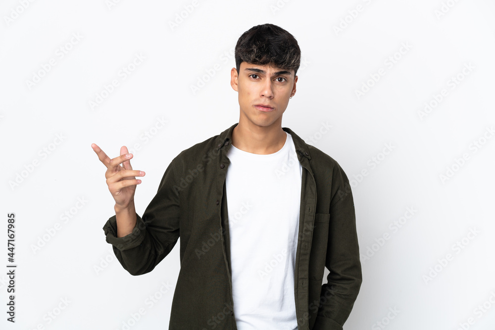 Young man over isolated white background making doubts gesture Young man over isolated white background making doubts gesture