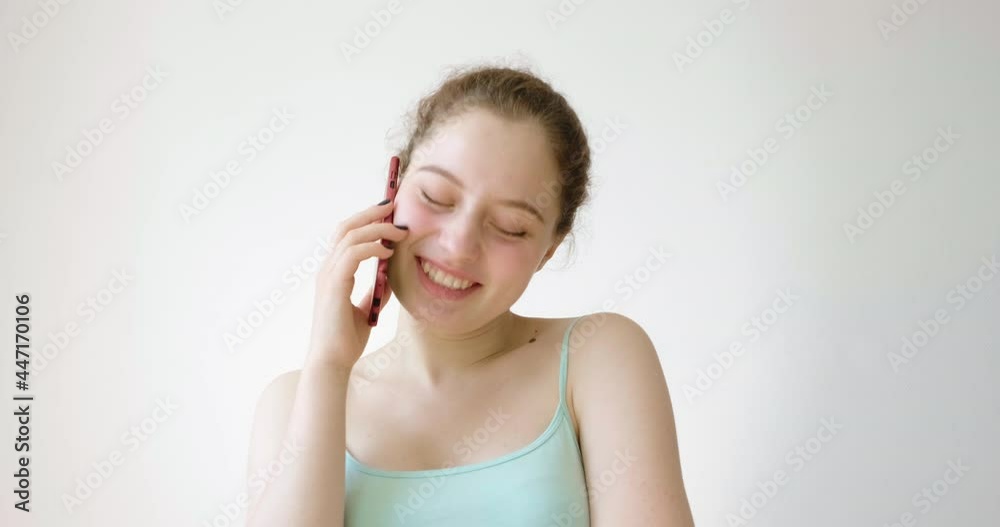The girl is emotionally talking on the phone with someone, she is happy. The girl is emotionally talking on the phone with someone, she is happy.