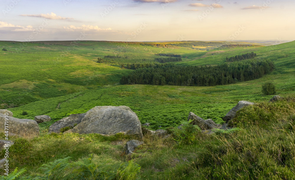 A Photograph of Stanage Edge Rocks and a View of a Far Rural Hill With Trees, at an English Countryside, in Peak District, Sheffield, England.