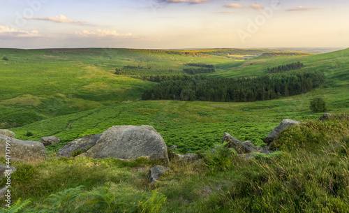 A Photograph of Stanage Edge Rocks and a View of a Far Rural Hill With Trees, at an English Countryside, in Peak District, Sheffield, England.