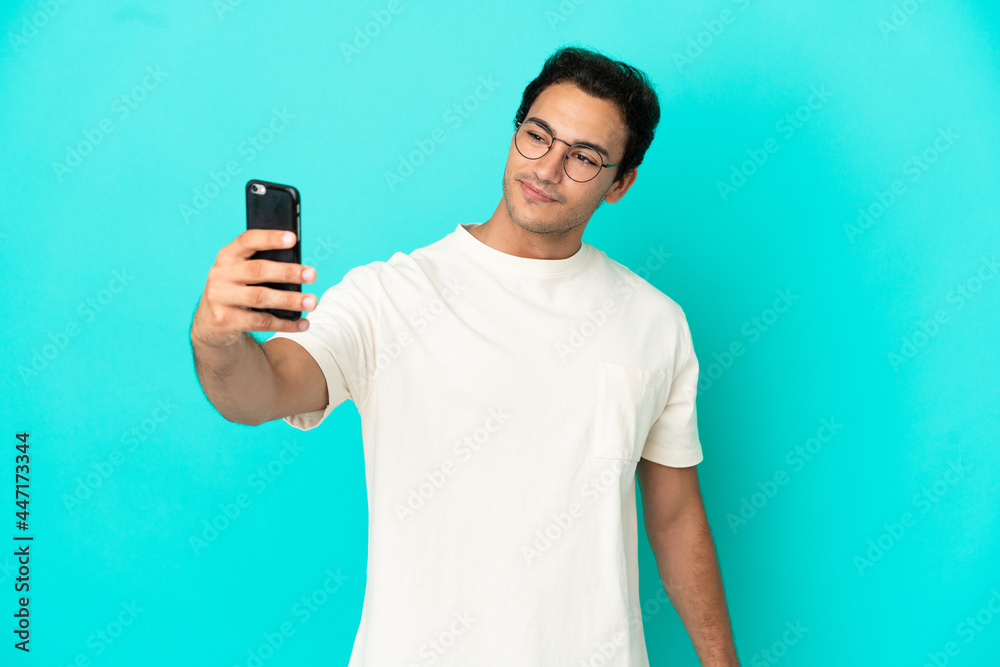 Caucasian handsome man over isolated blue background making a selfie Caucasian handsome man over isolated blue background making a selfie