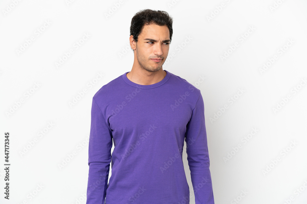 Caucasian handsome man over isolated white background having doubts while looking side Caucasian handsome man over isolated white background having doubts while looking side