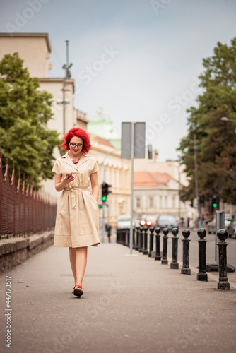 Beautiful young girl walking in the city, chatting on her telephone with a smile on her face © Teodor Lazarev