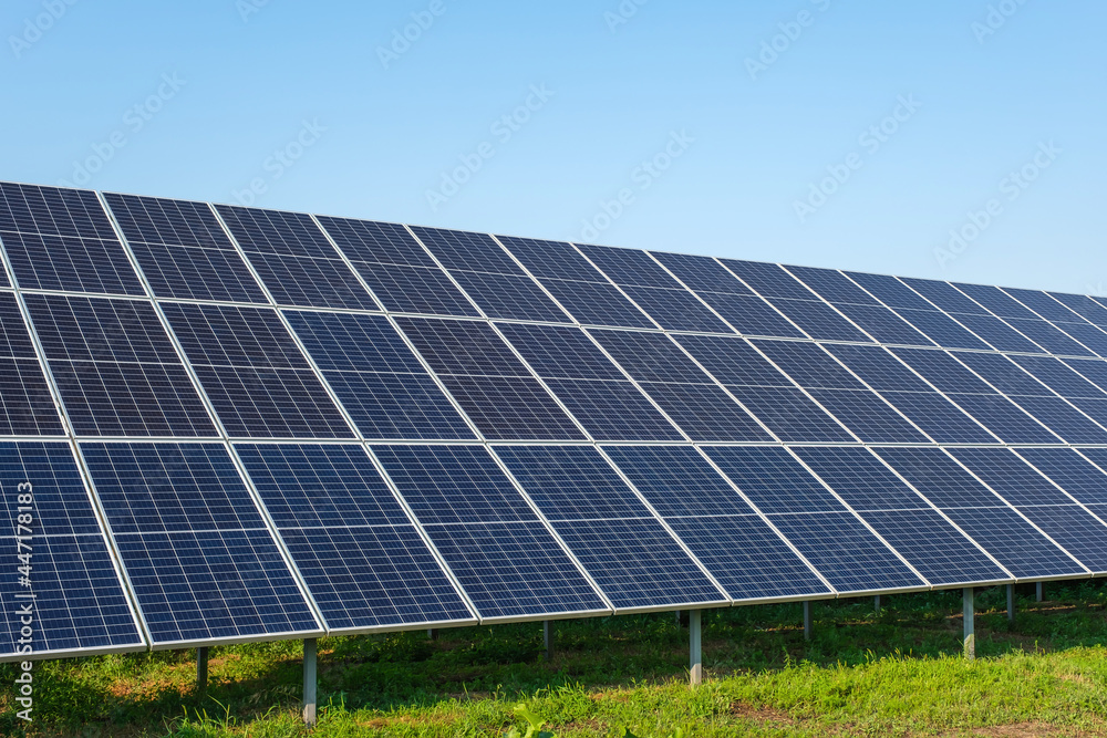 Row of solar panels on a solar farm under a blue sky. Row of solar panels on a solar farm under a blue sky.