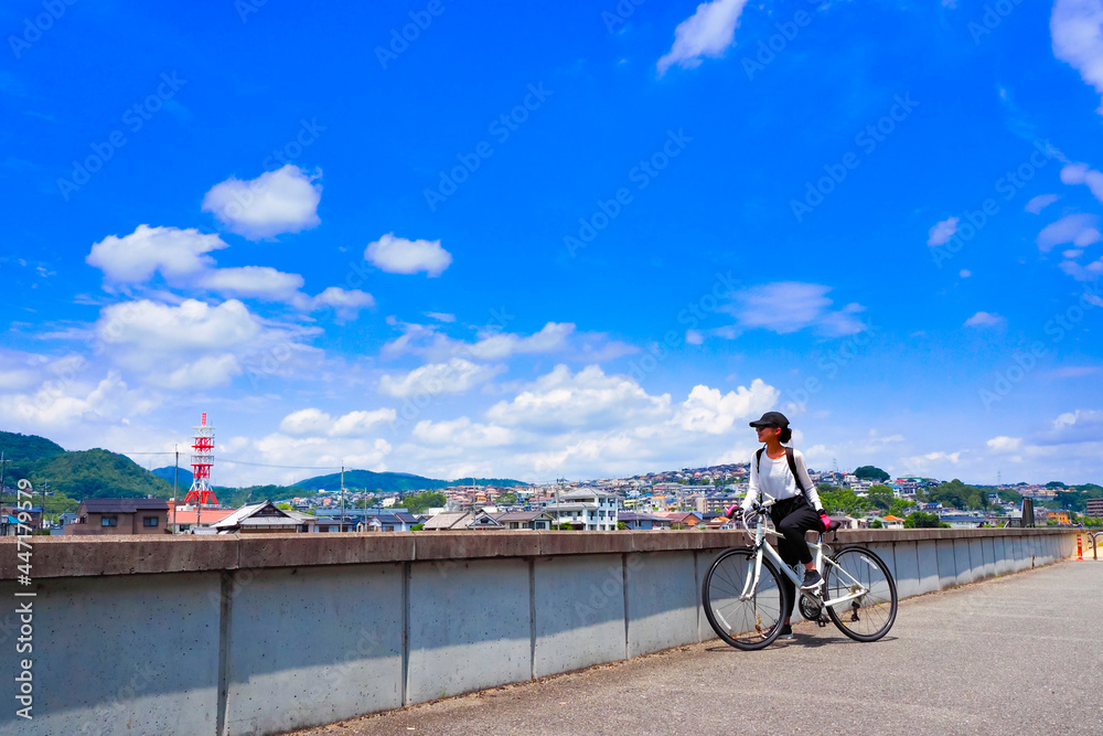 Fototapeta premium 青空と自転車の女性