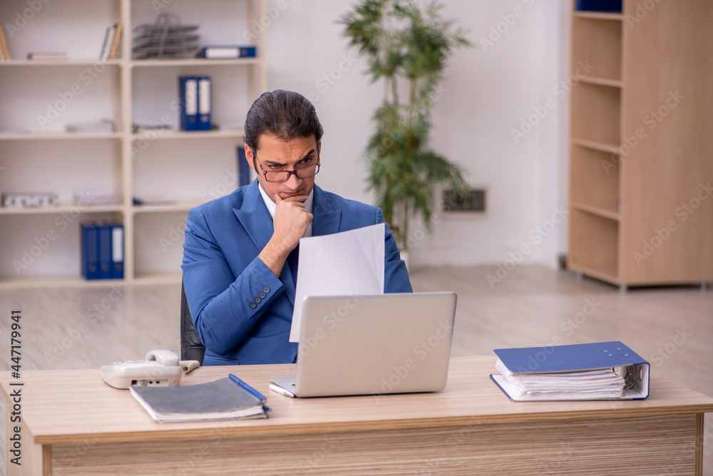 Young male employee sitting in the office Young male employee sitting in the office