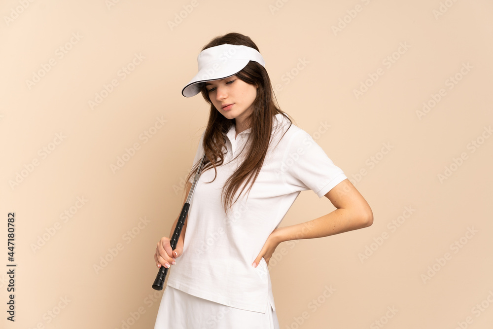 Young Ukrainian golfer girl isolated on beige background suffering from backache for having made an effort Young Ukrainian golfer girl isolated on beige background suffering from backache for having made an effort