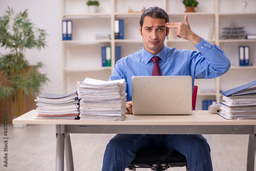 Young male employee unhappy with excessive work Young male employee unhappy with excessive work