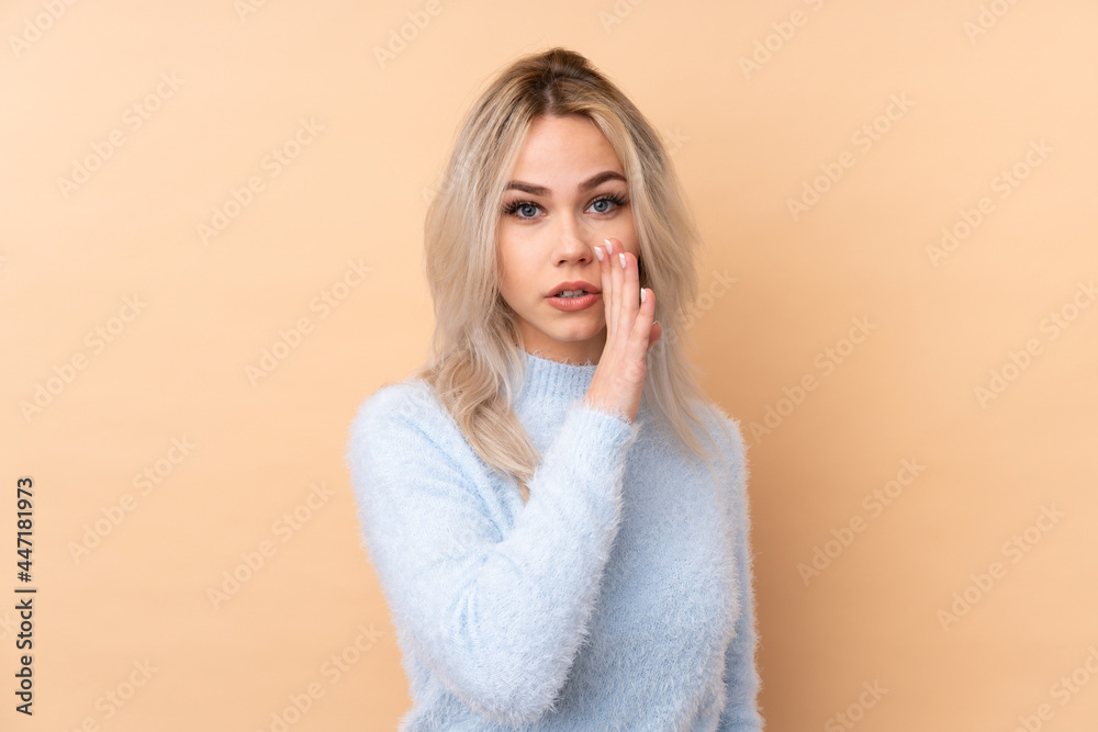 Teenager girl over isolated background whispering something