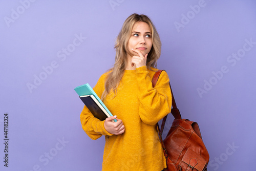 Teenager Russian student girl isolated on purple background having doubts and with confuse face expression