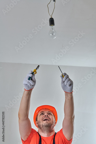 electrician repairing the light in the apartment