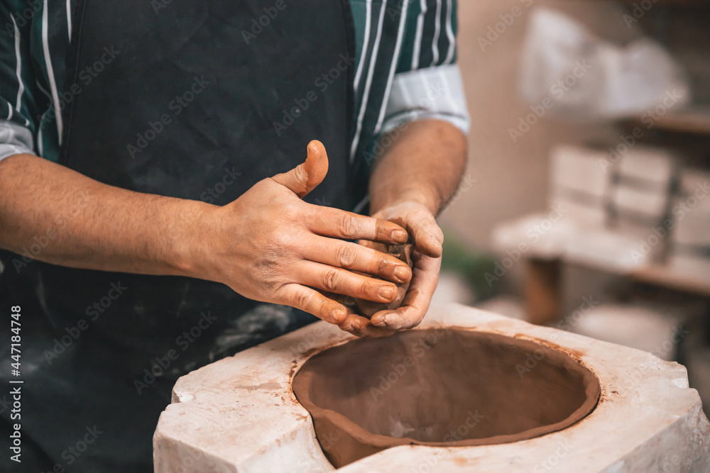 young adult potter molding with clay to make a piece of ceramic young adult potter molding with clay to make a piece of ceramic
