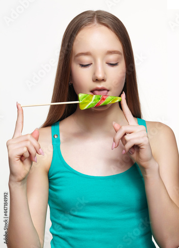 Teenager girl licking the lollipop. Sweet tooth concept
