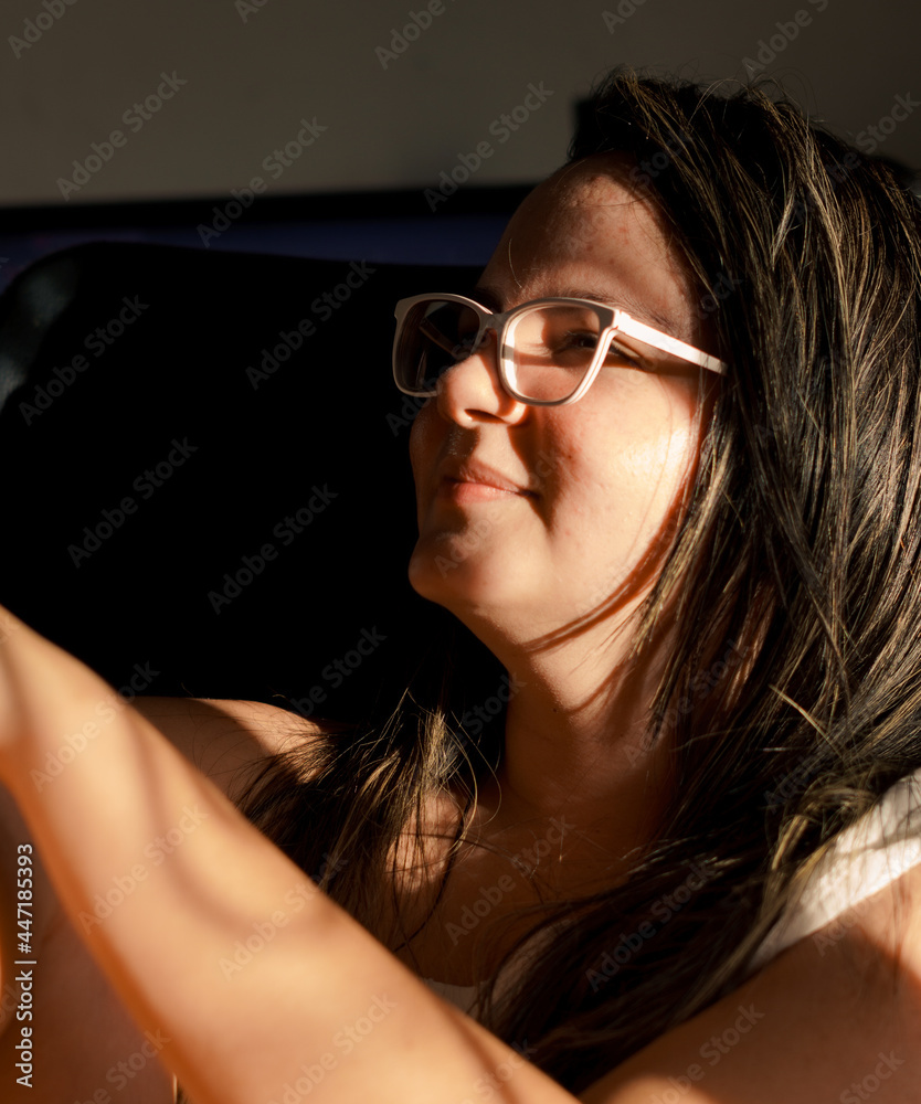 WHITE LATIN WOMAN WITH GLASSES IN FRONT OF THE LIGHT WHITE LATIN WOMAN WITH GLASSES IN FRONT OF THE LIGHT