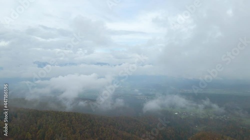 Backward moving aerial showing historic ancient church built on the peak of mountain range. photo