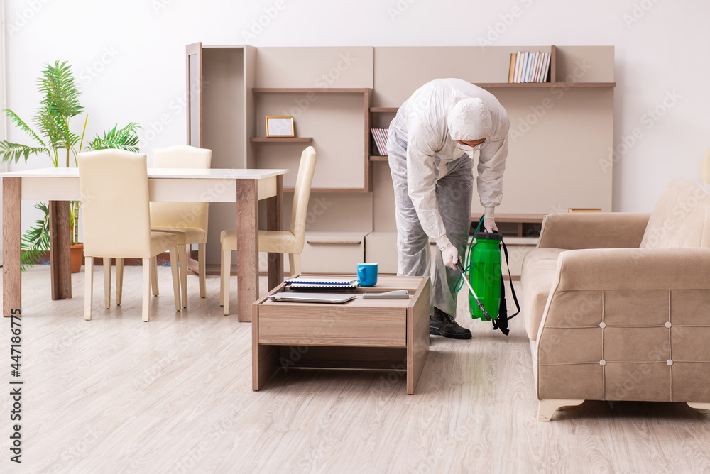 Fototapeta premium Young male contractor doing pest control at home
