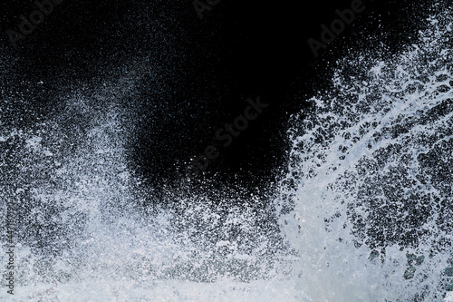 splashing of sea wave crashing on shore spraying white water foam