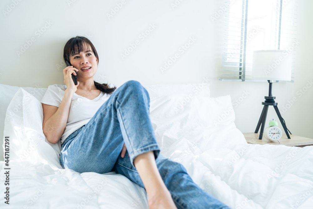 Asian attractive woman use mobile phone call on bed at home in morning Asian attractive woman use mobile phone call on bed at home in morning