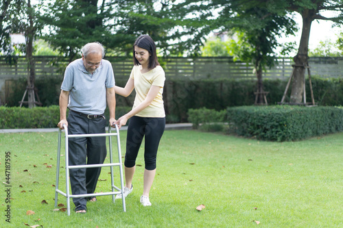 Asian girl daughter take care of disabled senior grandfather in garden