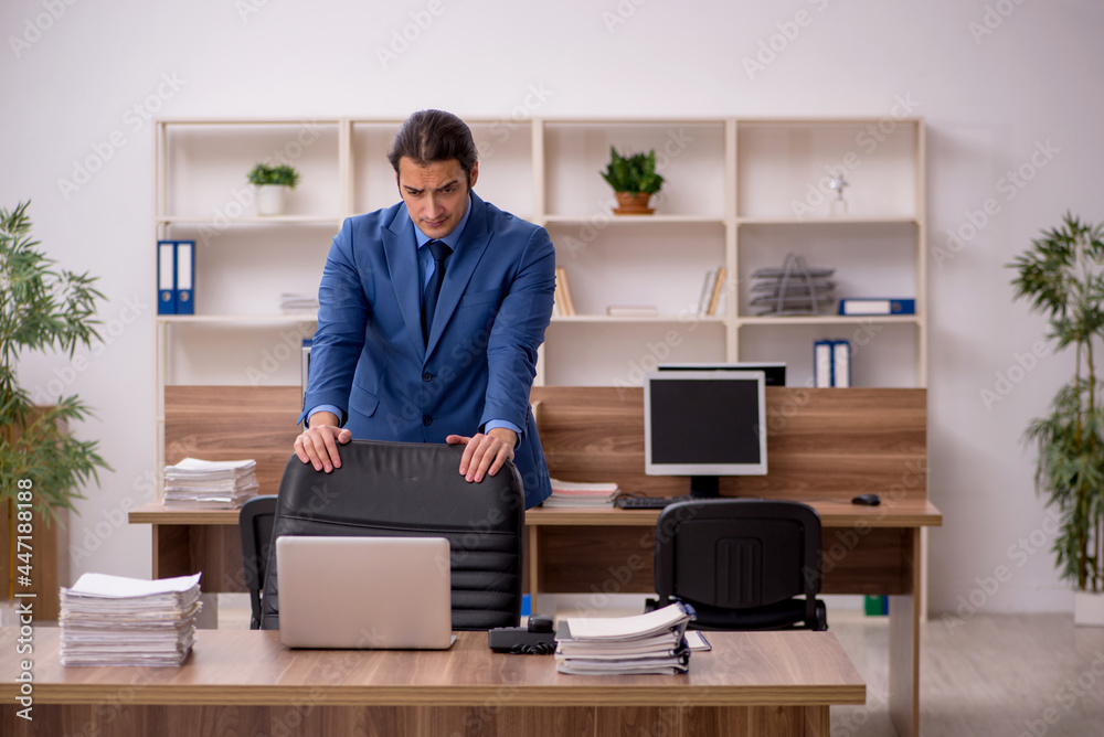 Young male employee and a lot of work in the office Young male employee and a lot of work in the office