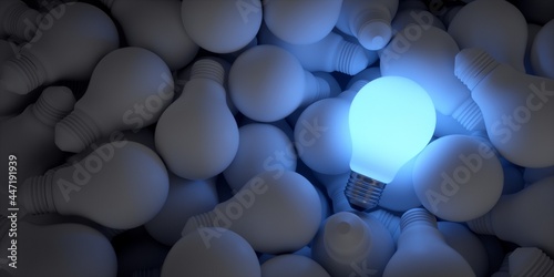 Big ideas. Illuminated blue light bulb among the rest of the unlit bulbs.  photo