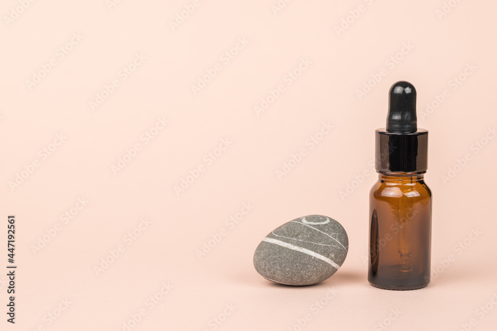 A beautiful blue stone and a bottle with an eyedropper on a beige background.