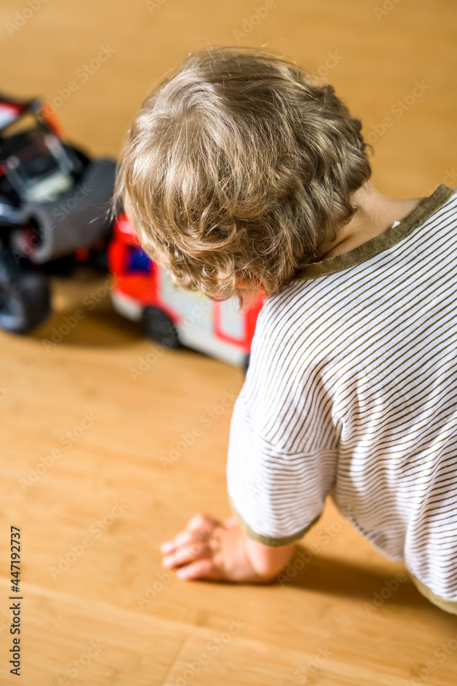 Little boy child is played with toy cars on wooden floor Little boy child is played with toy cars on wooden floor
