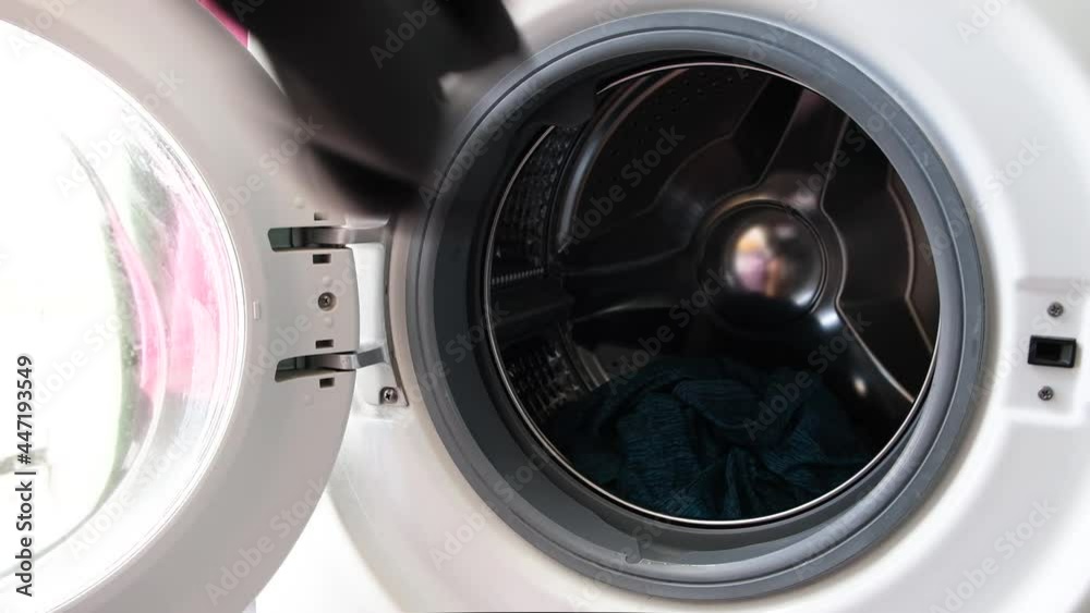 Woman's hand Pick up clothes Washing machine.Clean and Healthy Concepts. Woman's hand Pick up clothes Washing machine.Clean and Healthy Concepts.