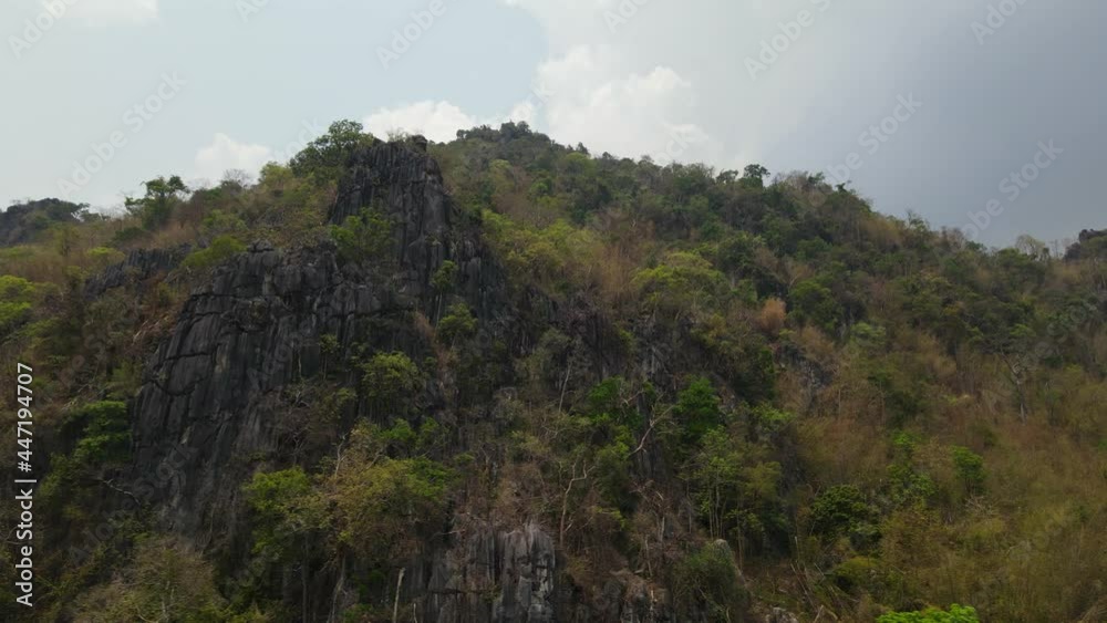4K aerial tracking shot of beautiful limestone rocky cliff covered with lush green forest found in the mountain range in Thailand Southeast Asia. 4K aerial tracking shot of beautiful limestone rocky cliff covered with lush green forest found in the mountain range in Thailand Southeast Asia.