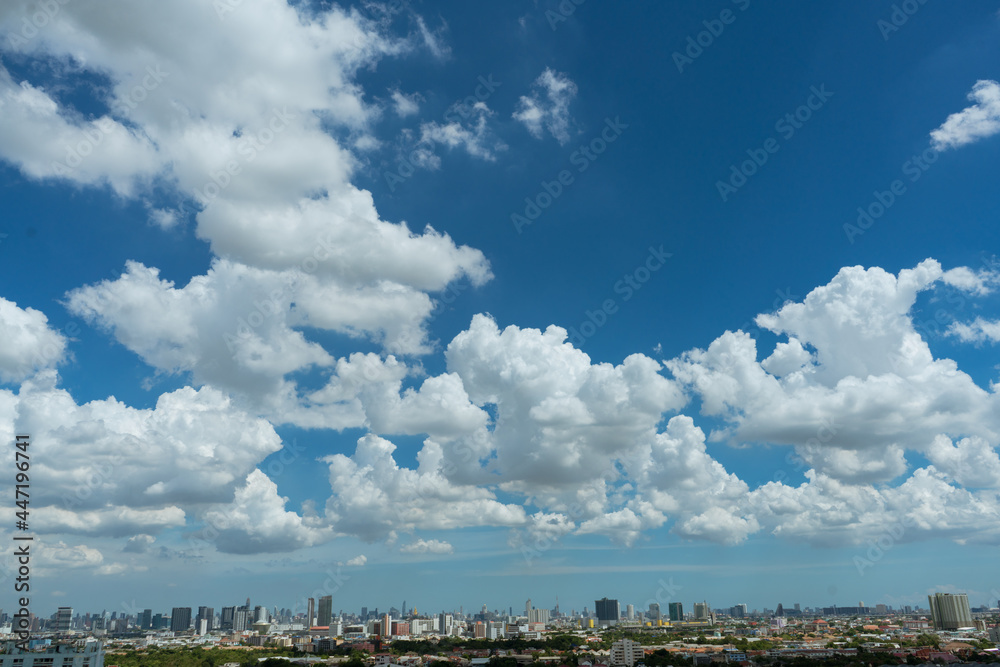 view of cityscape with sunny day and clouds over the sky