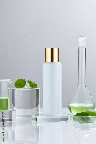Laboratory experiment and research with centella asiatica (gotu kola), oil and ingredient extract for natural beauty and organic cosmetic skincare product. The blank bottle for label science concept.