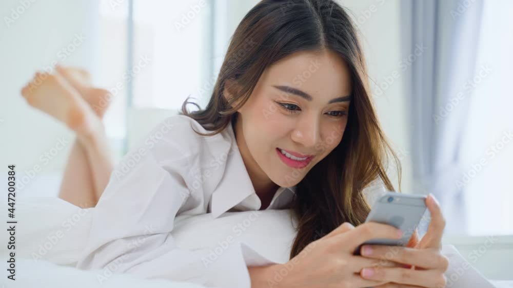 Asian attractive woman use mobile phone chat on bed at home in morning Asian attractive woman use mobile phone chat on bed at home in morning