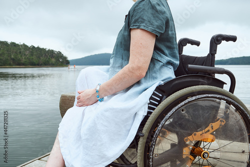 faceless portrait of a woman in a wheelchair on the background of nature