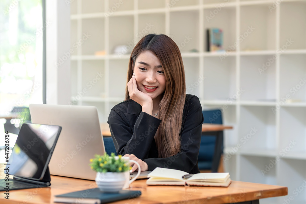 Beautiful Asian businesswoman sitting at the office using a laptop notebook place at the office. Beautiful Asian businesswoman sitting at the office using a laptop notebook place at the office.
