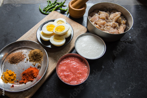 Assortment of raw cooking ingredients curd, spices, chicken pieces and egg boiled with use of selective focus