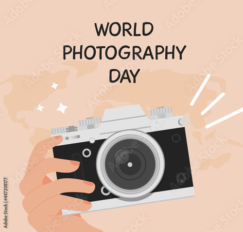 World photography day greeting card. Square banner with a hand holding digital camera in retro look. Background with world map. Vector illustration in flat cartoon style.