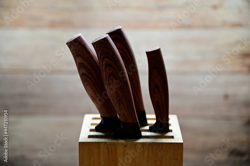 Set of old and new professional knives in a wooden box isolated on a wooden background. Warning, please use it carefully.