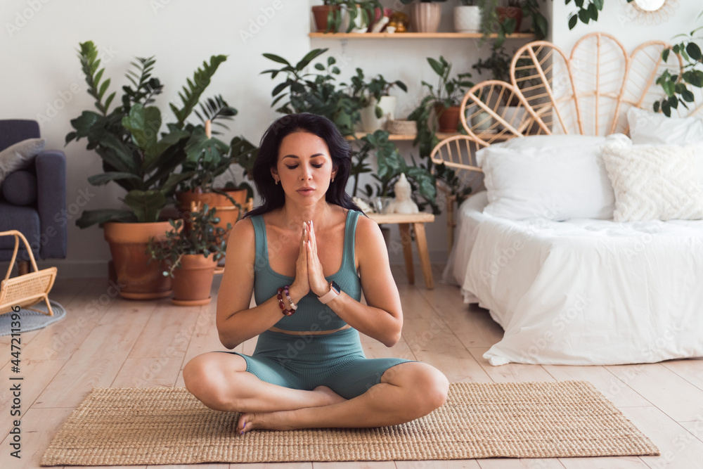 Woman doing yoga practice or meditation at home. Sitting on floor zen pose Woman doing yoga practice or meditation at home. Sitting on floor zen pose